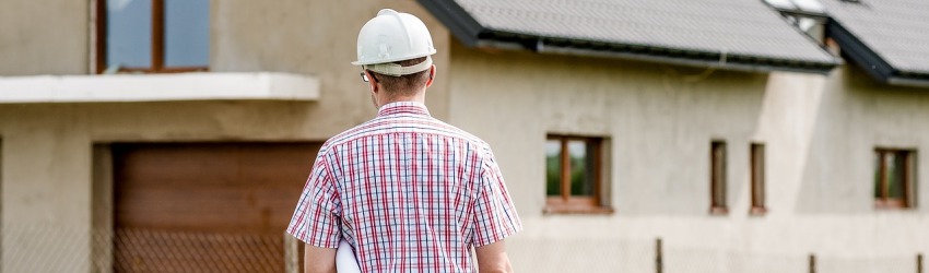 Uomo con progetti sottobraccio davanti ad una casa