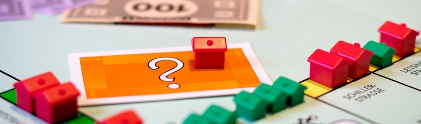 Gioco Monopoli con casette colorate, foglietto con punto di domande e soldi finti