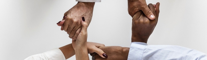 Vendite B2B: Mani di uomini e donne d'affari unite a formare una rete