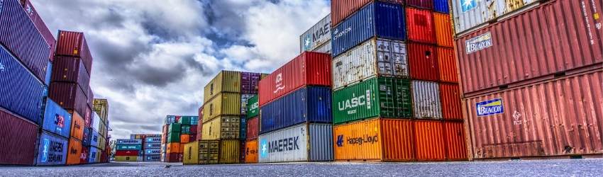 Permesso di costruzione casi: serie di container corolati sovrapposti, poggiati sull'asfalto con sfondo di cielo con nuvole